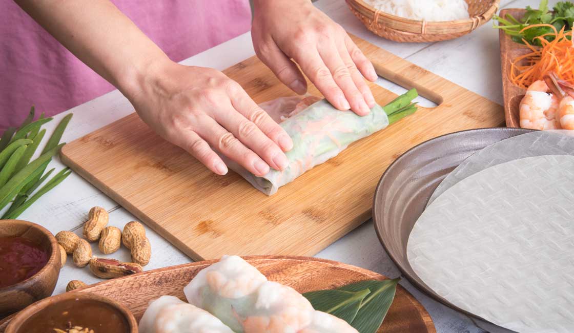 Hands assembling a spring roll